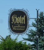 Metallschild in Schmiedeeisenrahmen mit vergoldeter Schrift